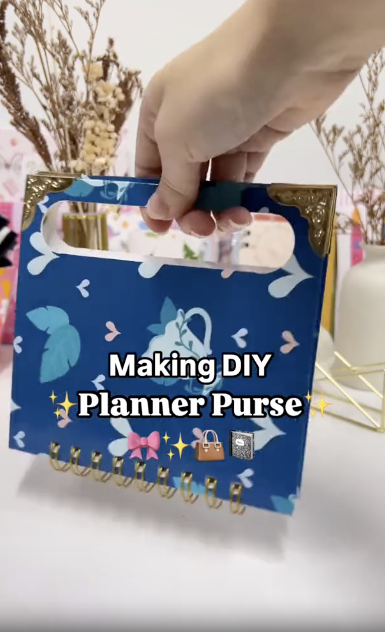 Finished DIY planner purse being carried by the handle cut into its chipboard cover